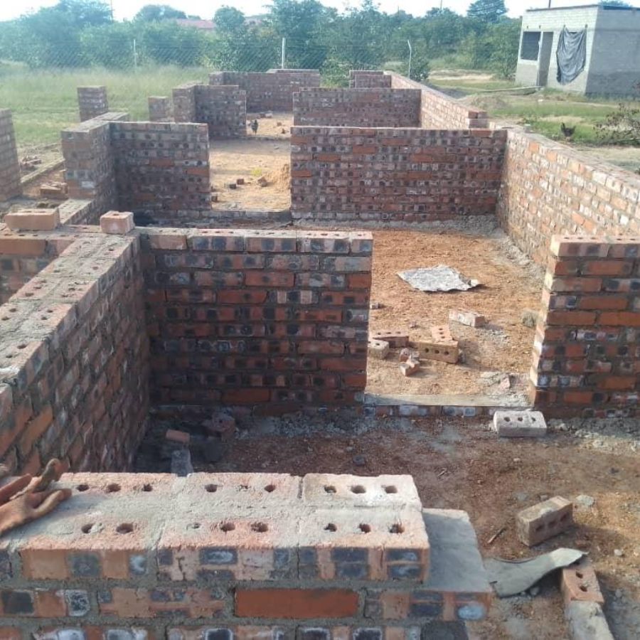 face brick building with roof trusses being fitted