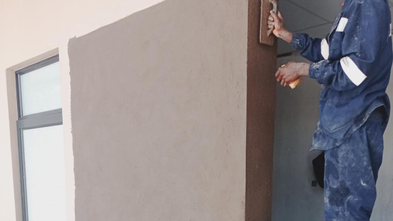 plasterer smoothing an exterior wall with a trowel