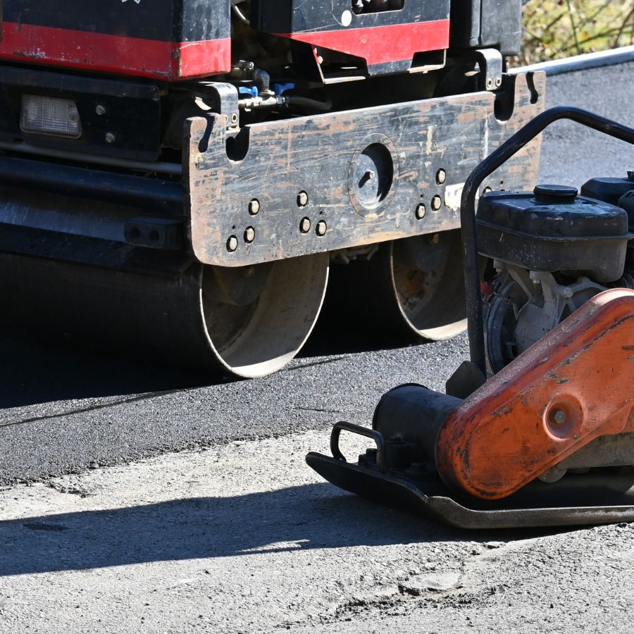 worker levelling asphalt with a hand tool