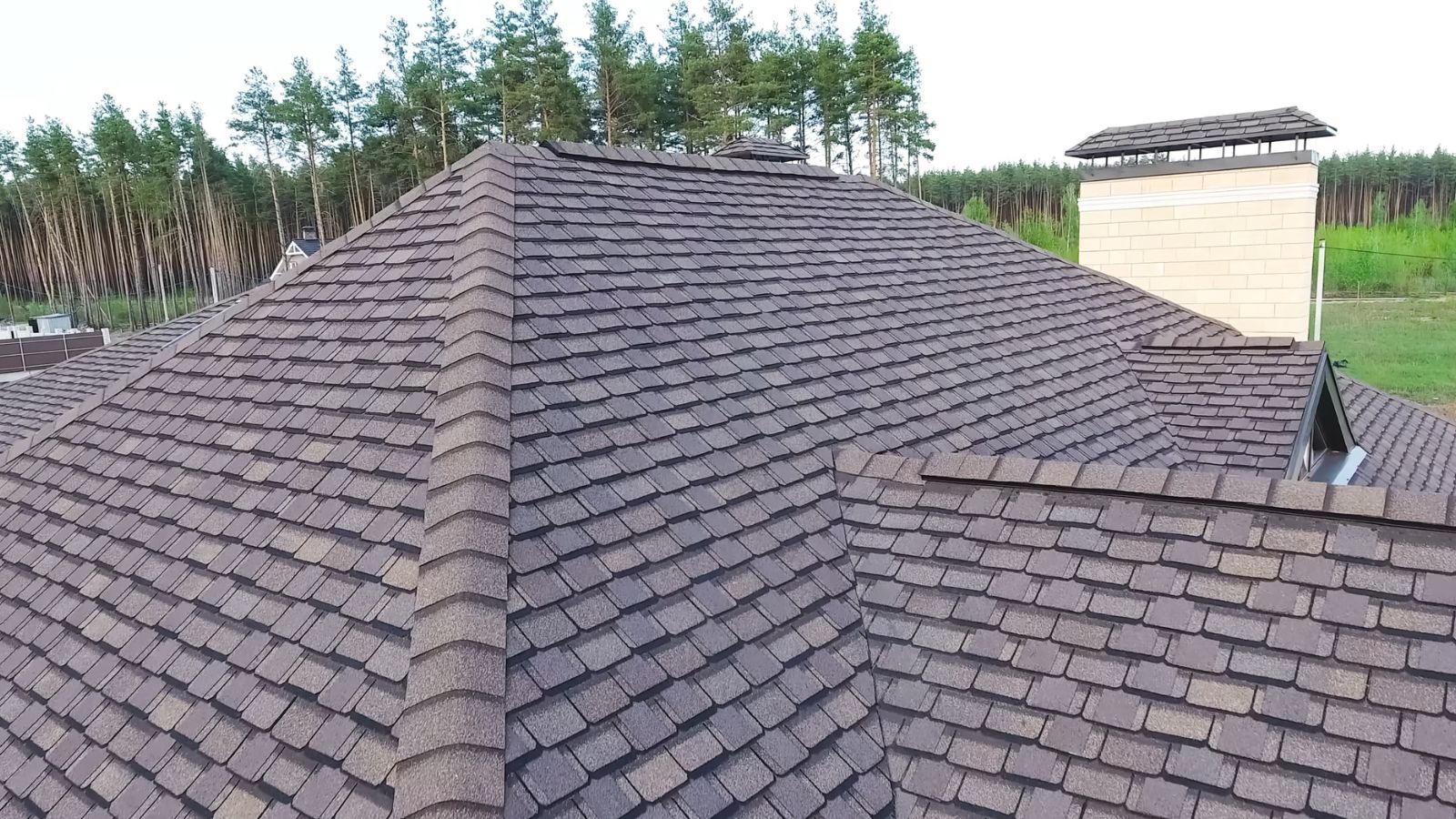 shingle roof on a completed house among trees