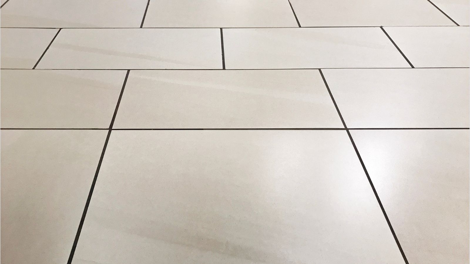 tiler setting floor tiles with adhesive